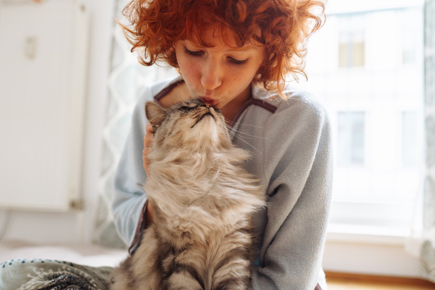 Woman kissing cat